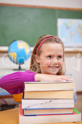 Portrait of schoolgirl posing with a stack of books