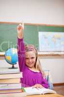 Portrait of young schoolgirl raising her hand
