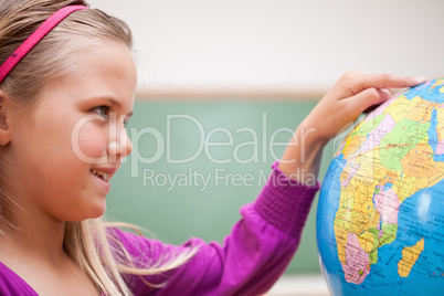 Close up of a cute schoolgirl looking at a globe