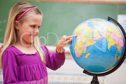 Cute schoolgirl pointing at a country