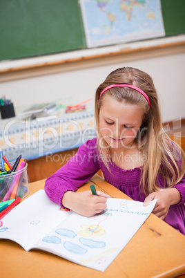 Portrait of a cute schoolgirl drawing