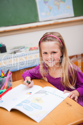 Portrait of a smiling schoolgirl drawing