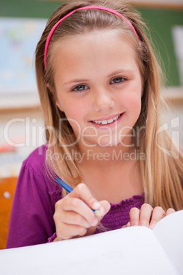 Portrait of a little schoolgirl writing