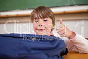 Cute schoolgirl posing with a bag and the thumb up