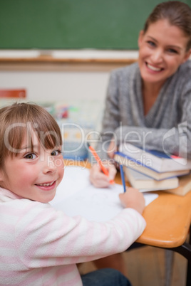 Portrait of a smiling teacher explaining something to her pupil