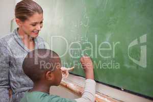 Cute teacher and a pupil making an addition