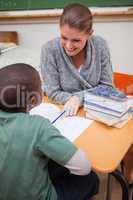 Portrait of a smiling teacher explaining something to a pupil