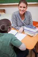 Portrait of a happy teacher explaining something to a pupil