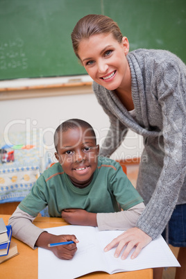 Portrait of a teacher explaining something to a smiling schoolbo