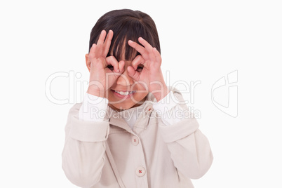 Girl putting her fingers around her eyes