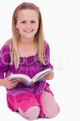 Portrait of a smiling girl reading a book