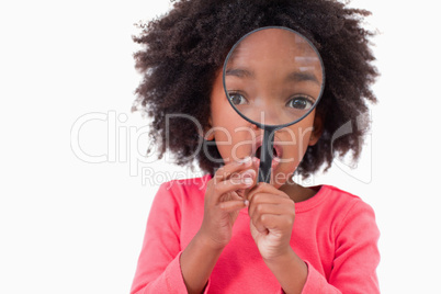 Girl looking through a magnifying glass