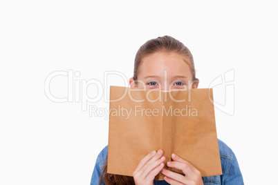 Girl hiding her face behind a book