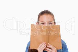 Girl hiding her face behind a book