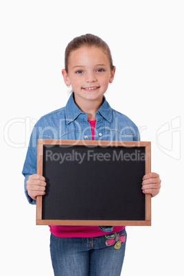 Portrait of a young girl holding a school slate