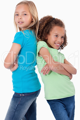 Portrait of smiling girls standing back to back