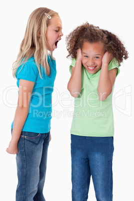 Portrait of an angry girl screaming at her friend