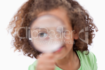 Smiling girl looking through a magnifying glass