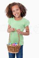 Portrait of a young girl holding a basket full of Easter eggs