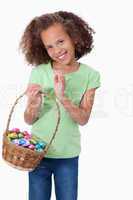 Portrait of a cute girl holding a basket full of Easter eggs