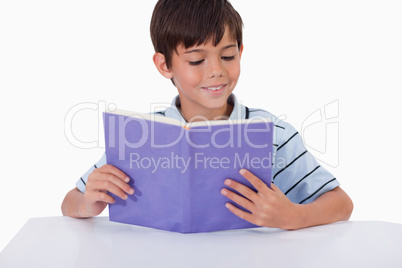 Smiling boy reading a book