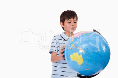 Smiling boy looking at a globe