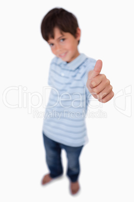 Portrait of a happy boy smiling at the camera with the thumb up