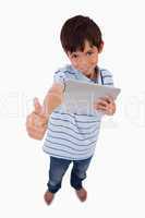 Portrait of a boy using a tablet computer with the thumb up