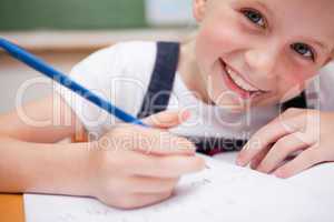 Close up of a smiling schoolgirl writing something