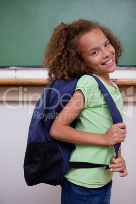 Portrait of a schoolgirl showing her backpack