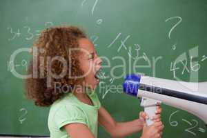 Side view of a schoolgirl screaming through a megaphone