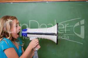 Young schoolgirl screaming through a megaphone
