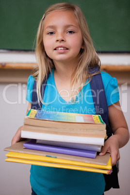 Portrait of a happy schoolgirl holding her books