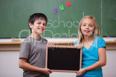Smiling pupils holding a school slate