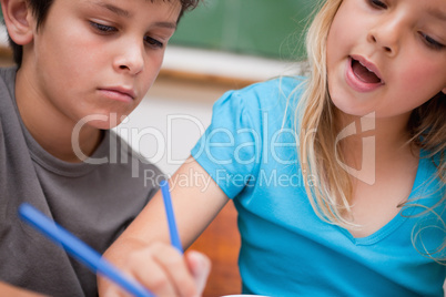 Close up of two children writing