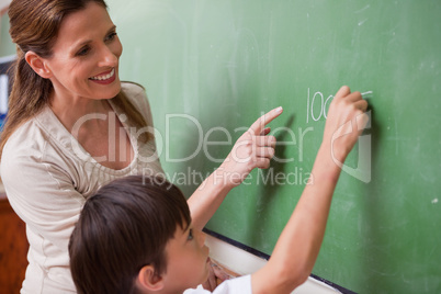 Schoolteacher helping a schoolboy doing an addition