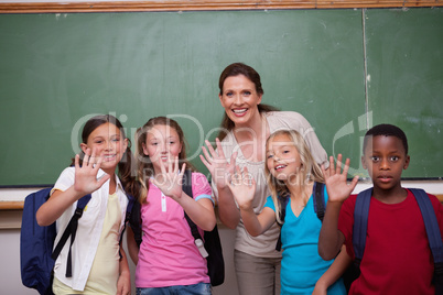 Schoolteacher and her pupils waving at the camera