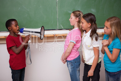 Schoolboy yelling through a megaphone to his classmates