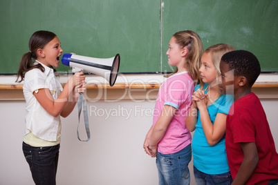 Angry schoolgirl screaming through a megaphone to her classmates