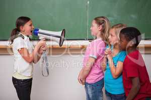 Angry schoolgirl screaming through a megaphone to her classmates