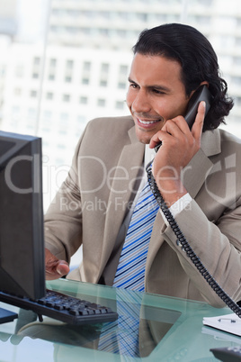 Portrait of a businessman working with a monitor while being on