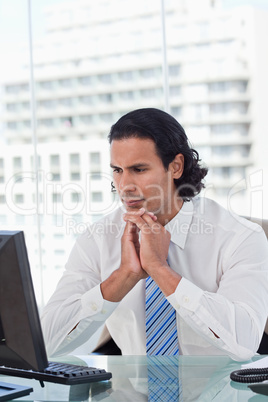 Portrait of a businessman thinking while using a computer