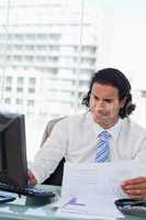 Portrait of a businessman using a computer while looking at stat