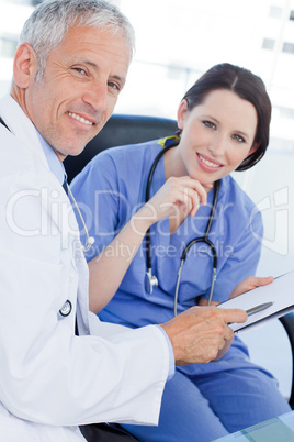 Portrait of a smiling medical team looking a document