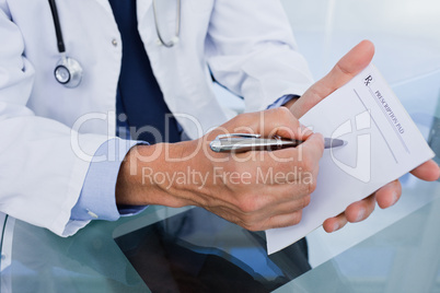 Close up of a male doctor showing a blank prescription sheet