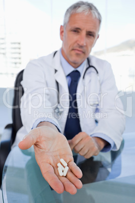 Portrait of a doctor showing pills