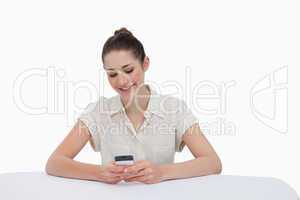 Smiling businesswoman writing a text message