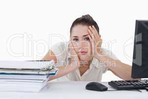 Tired businesswoman leaning on her desk
