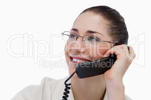 Close up of a smiling secretary making a phone call
