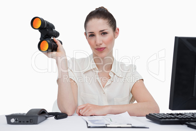 Businesswoman holding binoculars